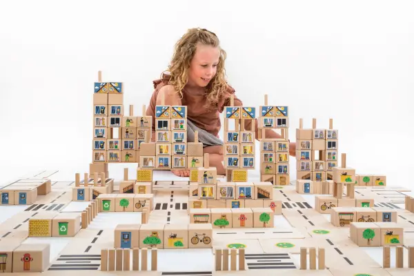 The girl is building a city with blocks.