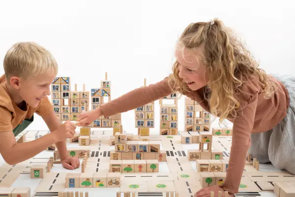 The boy is building a city with Just Blocks City.