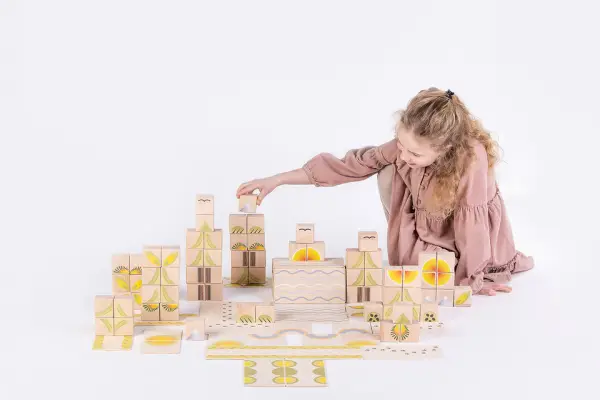 girl arranges wooden blocks