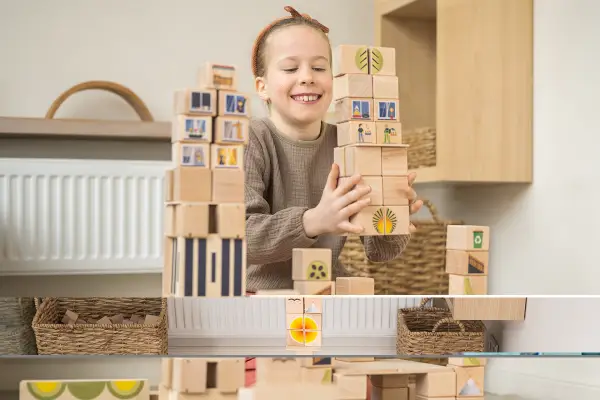 The girl is playing with wooden blocks.